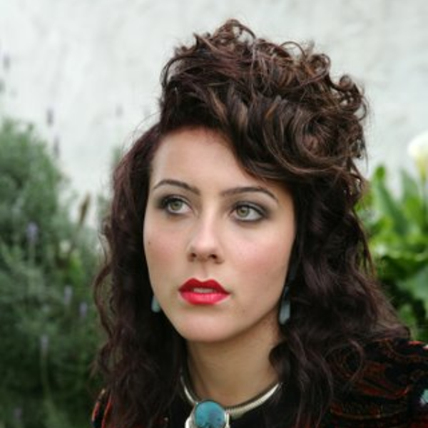 Woman with an elegant hair up hairstyle featuring a polished updo and soft face-framing strands.